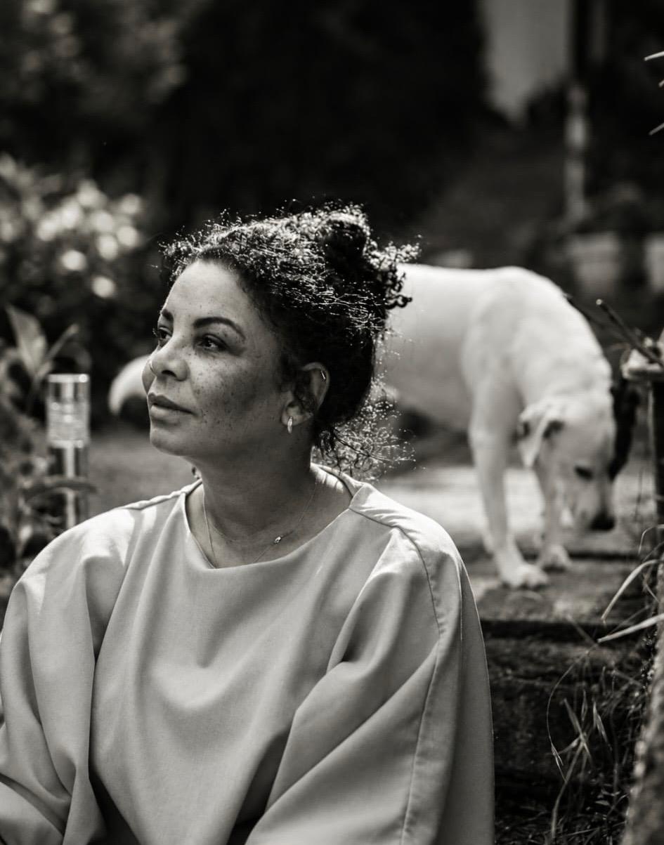 Stefanie im Garten, in Schwarz-Weiß, nachdenklich in die Ferne blickend